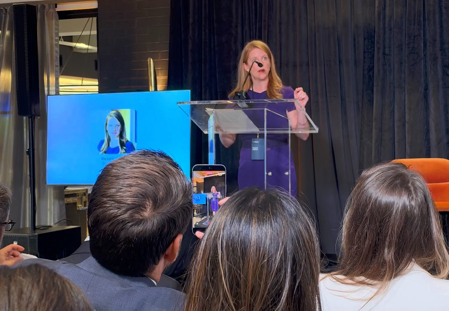A speaker addressing the audience from a clear lectern at Meta's event.